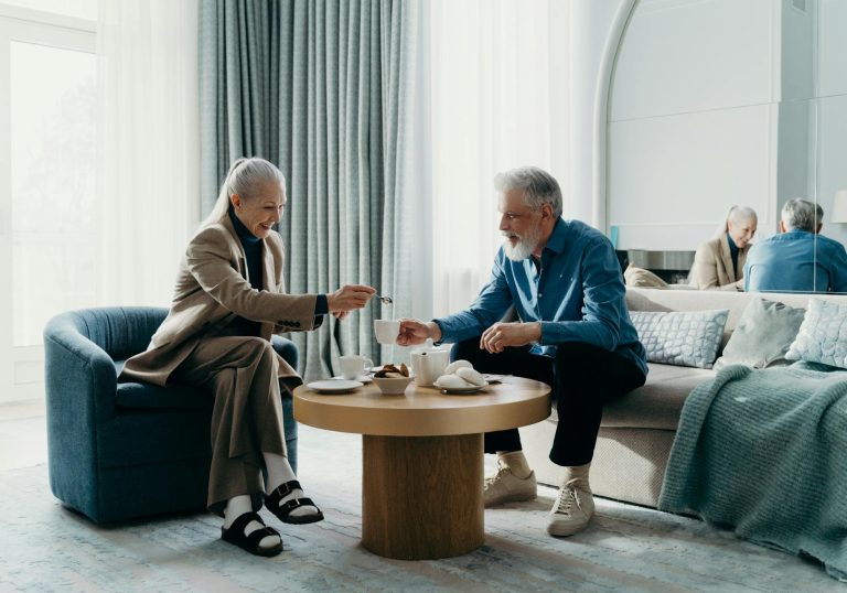 Elderly couple relaxing with coffee indoors, enjoying leisure time together.
