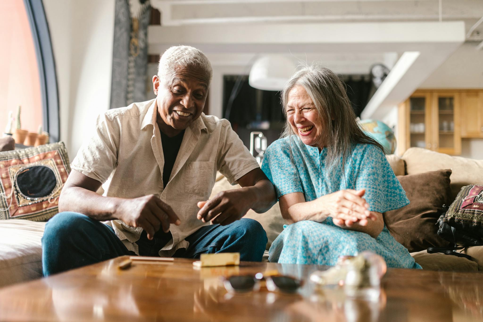 Happy senior couple laughing and enjoying time together at home on the sofa.