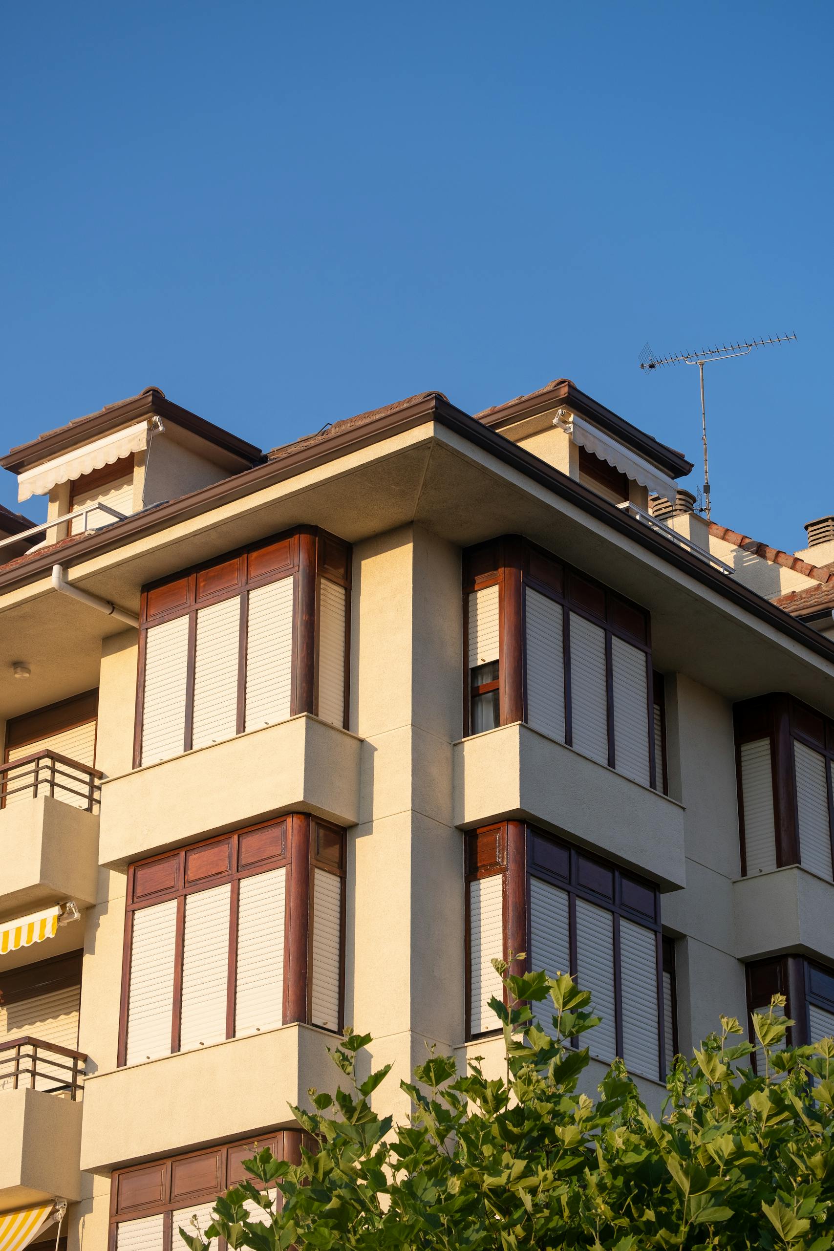 Close-up of a modern residential building with clear blue sky background.